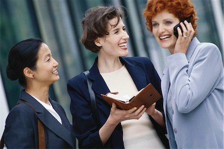 simsearch:695-03376228,k - Three businesswoman, one holding agenda, one using cell phone Stock Photo - Premium Royalty-Free, Code: 695-03374516