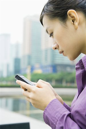 Businesswoman using messaging phone, close-up, side view Stock Photo - Premium Royalty-Free, Code: 695-03374749