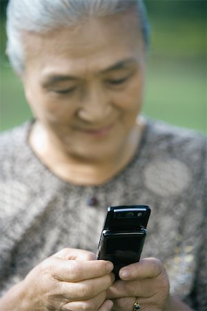 phone one person adult smile elderly - Senior woman dialing cell phone Stock Photo - Premium Royalty-Free, Code: 695-03374952