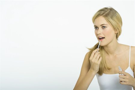 female lips silhouette - Teenage girl putting on lipgloss Stock Photo - Premium Royalty-Free, Code: 695-03375334