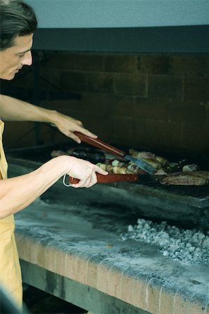Man grilling meat on barbecue Stock Photo - Premium Royalty-Free, Code: 695-03375492