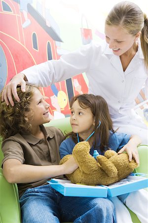 simsearch:695-05768235,k - Boy and girl playing doctor with teddy bear while nurse watches Stock Photo - Premium Royalty-Free, Code: 695-03375874