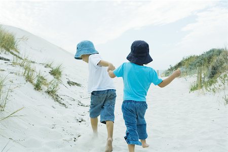 Children running through dunes, holding hands Stock Photo - Premium Royalty-Free, Code: 695-03375940