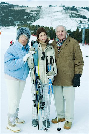 simsearch:696-03401677,k - Senior couple standing on ski slope with teen granddaughter holding ski gear Stock Photo - Premium Royalty-Free, Code: 695-03376186