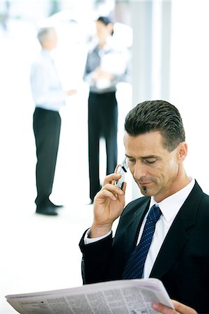 simsearch:695-03376228,k - Businessman using cell phone, looking at newspaper Stock Photo - Premium Royalty-Free, Code: 695-03376229