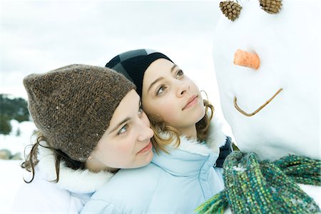 simsearch:695-03376478,k - Two teenage girls looking at snowman together, one's head on the other's shoulder Foto de stock - Sin royalties Premium, Código: 695-03376332