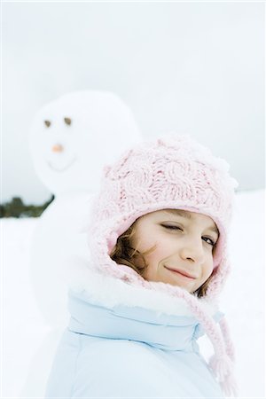 simsearch:695-03376367,k - Girl winking at camera, snowman in background Stock Photo - Premium Royalty-Free, Code: 695-03376387