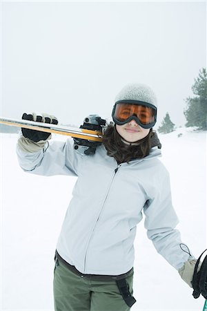 simsearch:695-03376478,k - Teenage girl carrying skis on shoulder, smiling at camera Foto de stock - Sin royalties Premium, Código: 695-03376465