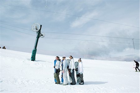 simsearch:695-03376478,k - Four young snowboarders standing, lined up, looking up, mid-distance Foto de stock - Sin royalties Premium, Código: 695-03376485