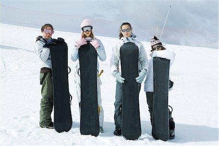 simsearch:695-03376478,k - Four young friends standing together, holding snowboards, looking at camera Foto de stock - Sin royalties Premium, Código: 695-03376486