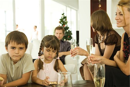 simsearch:695-03380694,k - Two children holding Christmas ornaments, adults drinking champagne Stock Photo - Premium Royalty-Free, Code: 695-03376517