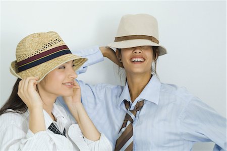 simsearch:695-03376693,k - Deux jeunes amis porter un chapeau, sourire aux lèvres, les yeux couverts Photographie de stock - Premium Libres de Droits, Code: 695-03376685