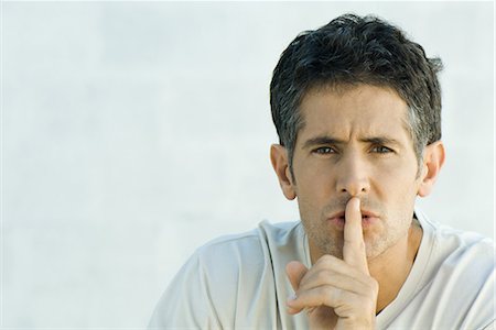 shhh - Mature man holding finger over lips, looking at camera, portrait Stock Photo - Premium Royalty-Free, Code: 695-03376722