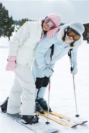 simsearch:695-03376478,k - Two young skiers standing together, smiling at camera, one leaning on the other's shoulder, portrait Foto de stock - Sin royalties Premium, Código: 695-03376846