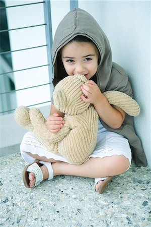 pictures of a little girl whispering - Little girl sitting on floor, whispering into teddy bear's ear, full length Stock Photo - Premium Royalty-Free, Code: 695-03377023