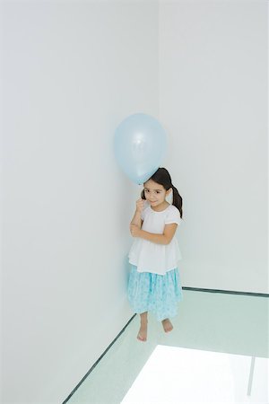 simsearch:632-01193783,k - Girl standing in corner holding balloon, looking up at camera Stock Photo - Premium Royalty-Free, Code: 695-03377273
