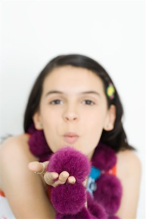 Teenage girl wearing boa, blowing kiss at camera Stock Photo - Premium Royalty-Free, Code: 695-03377339