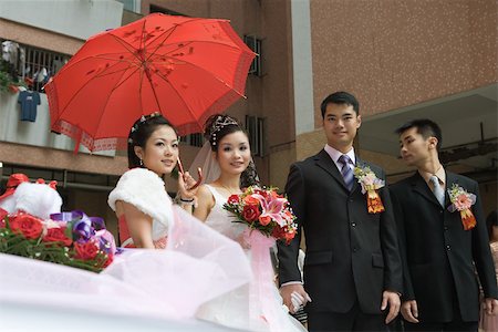 Chinese wedding, bride and groom standing with bridesmaid and best man Stock Photo - Premium Royalty-Free, Code: 695-03377443