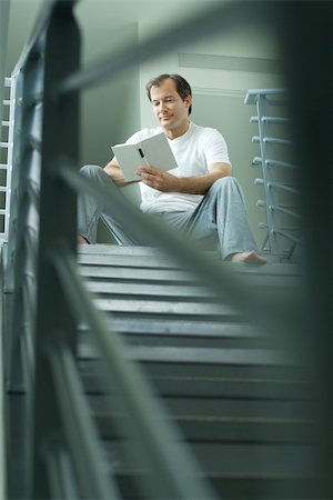 simsearch:632-03083700,k - Man sitting at top of staircase reading book, selective focus Stock Photo - Premium Royalty-Free, Code: 695-03377904