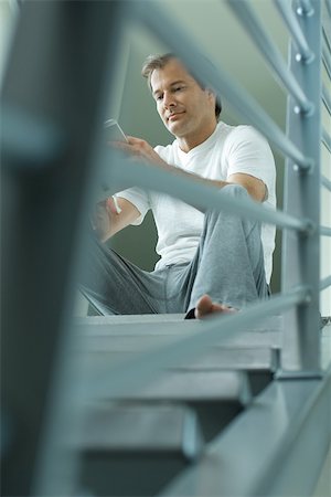 simsearch:632-03083700,k - Man sitting on stairs reading book, low angle view Stock Photo - Premium Royalty-Free, Code: 695-03377905
