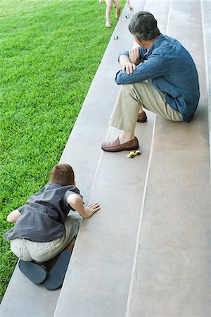 simsearch:632-03424261,k - Grandfather and grandchildren sitting on steps, playing with toy cars, high angle view Stock Photo - Premium Royalty-Free, Code: 695-03378012
