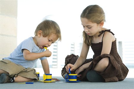 simsearch:695-05768235,k - Brother and sister sitting on the ground, playing with plastic teacups together Stock Photo - Premium Royalty-Free, Code: 695-03378032