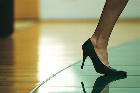 Woman walking in high heels, cropped view of foot Stock Photo - Premium Royalty-Free, Code: 695-03378125