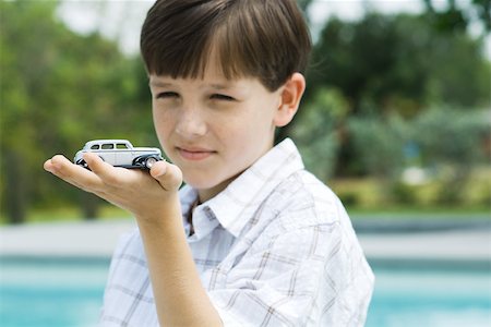 pool child - Boy holding toy car in palm of hand Foto de stock - Sin royalties Premium, Código: 695-03378177