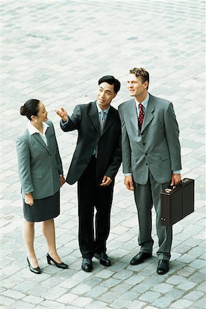 simsearch:695-03376228,k - Three professionals standing together outdoors, one gesturing with hand, two looking up, high angle view Stock Photo - Premium Royalty-Free, Code: 695-03378362