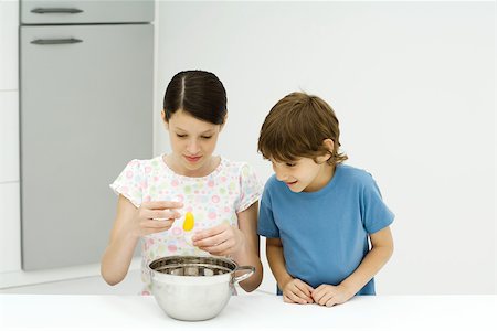 simsearch:695-03378605,k - Two young siblings cooking together, girl cracking egg, both looking down Stock Photo - Premium Royalty-Free, Code: 695-03378450