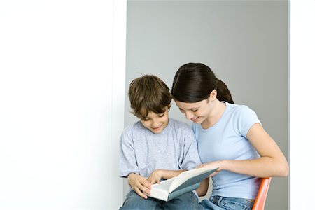 simsearch:695-03378605,k - Brother and sister sitting, reading book together, both smiling Stock Photo - Premium Royalty-Free, Code: 695-03378585
