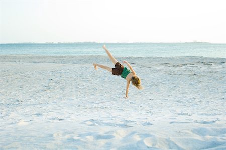 simsearch:633-01714467,k - Little girl doing cartwheel at the beach, rear view Stock Photo - Premium Royalty-Free, Code: 695-03378649