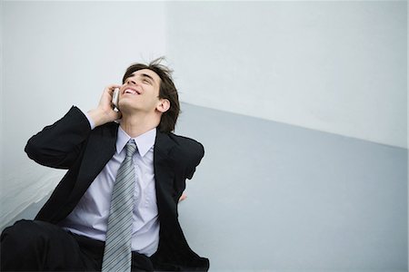 simsearch:695-03376228,k - Young man in suit sitting on the ground, using cell phone, head back Stock Photo - Premium Royalty-Free, Code: 695-03378933