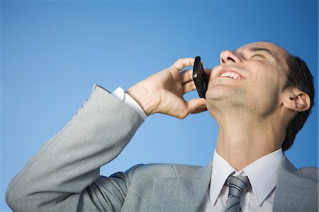 simsearch:695-03376228,k - Businessman using cell phone, smiling, head back Stock Photo - Premium Royalty-Free, Code: 695-03378940