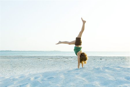Girl doing handstand on beach Stock Photo - Premium Royalty-Free, Code: 695-03379334