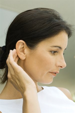 Woman pushing hair behind ear, close-up Stock Photo - Premium Royalty-Free, Code: 695-03379355