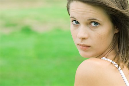 Teen girl looking over shoulder at camera, close-up Stock Photo - Premium Royalty-Free, Code: 695-03379362