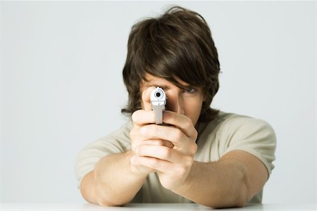revolve - Young man aiming gun at camera Stock Photo - Premium Royalty-Free, Code: 695-03379375