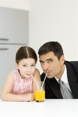 simsearch:632-01193783,k - Father and daughter sharing glass of orange juice, drinking from straws, looking at camera Stock Photo - Premium Royalty-Free, Code: 695-03379424