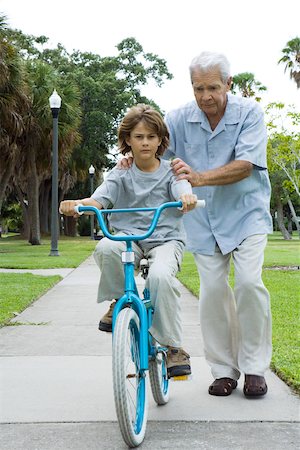 Grandfather teaching boy to ride bicycle, full length Stock Photo - Premium Royalty-Free, Code: 695-03379460