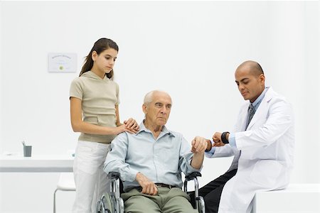Doctor measuring elderly man's pulse, preteen girl watching Stock Photo - Premium Royalty-Free, Code: 695-03379561
