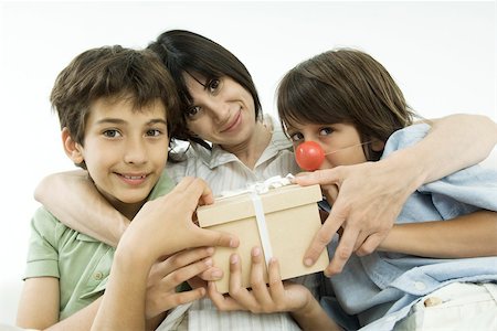 simsearch:695-05769087,k - Mother sitting with two sons, holding gift, smiling at camera Stock Photo - Premium Royalty-Free, Code: 695-03379674