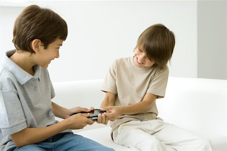 play-fighting - Two brothers fighting over handheld video game Stock Photo - Premium Royalty-Free, Code: 695-03379701