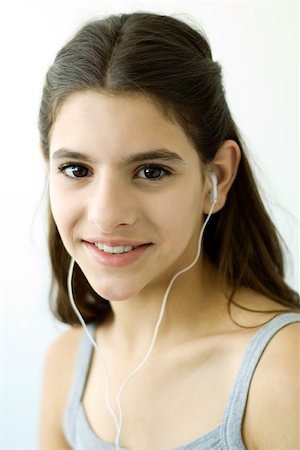 simsearch:400-05697219,k - Teen girl listening to earphones, smiling at camera Stock Photo - Premium Royalty-Free, Code: 695-03379865