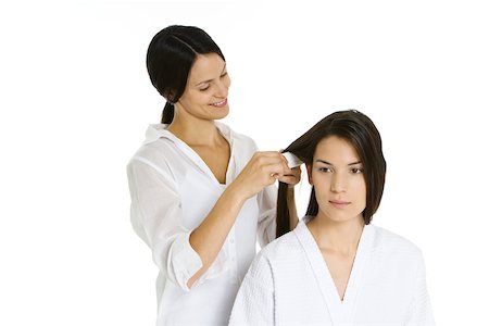 simsearch:693-06323962,k - Hair stylist combing woman's hair, both looking away Stock Photo - Premium Royalty-Free, Code: 695-03379974