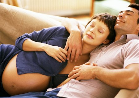 pregnant couple couch - Pregnant woman leaning head on man's chest, on sofa Foto de stock - Sin royalties Premium, Código: 695-03384058