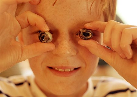 escargot - Child holding escargot in front of eyes, close-up Stock Photo - Premium Royalty-Free, Code: 695-03384592