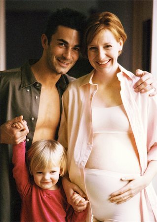 simsearch:400-04866555,k - Pregnant woman and man standing with child, smiling, portrait Foto de stock - Sin royalties Premium, Código: 695-03384767