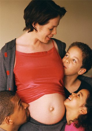 Man and children around pregnant woman's exposed stomach Stock Photo - Premium Royalty-Free, Code: 695-03384799