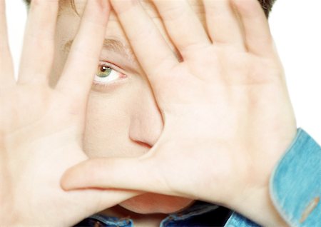 Teenage boy with hands in front of face, close-up Stock Photo - Premium Royalty-Free, Code: 695-03385046